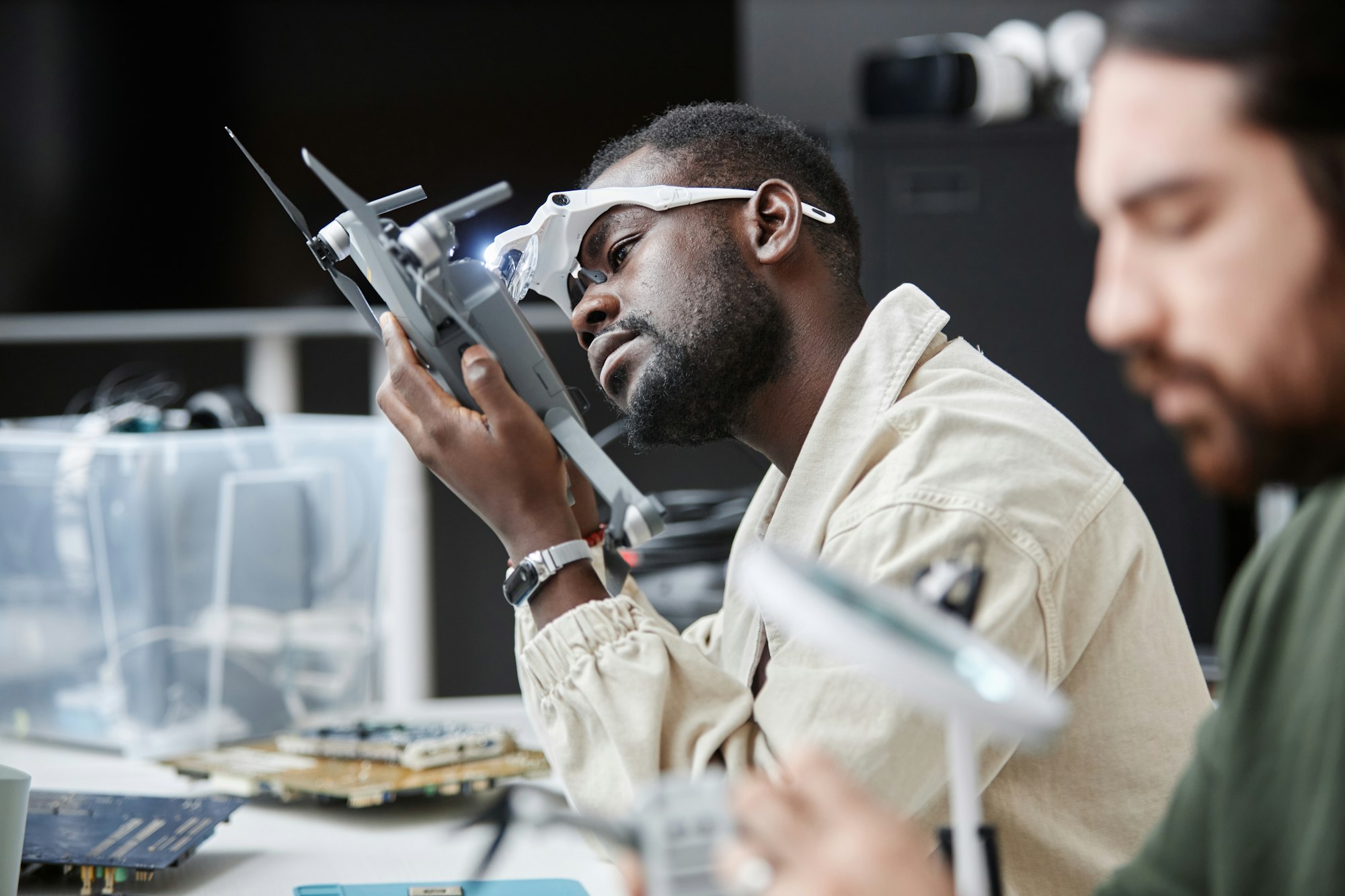 Black Man Disassembling Drone in Repair Shop
